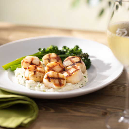 Caramelized Grilled Sea Scallops served with broccolini and mascarpone risotto. by Seasons 52