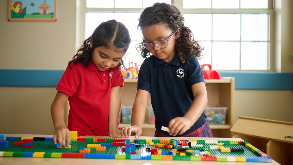 Primrose Schools preschool girls collaborating on LEGO building activity in structured early learning environment by Primrose School at Vista Ridge
