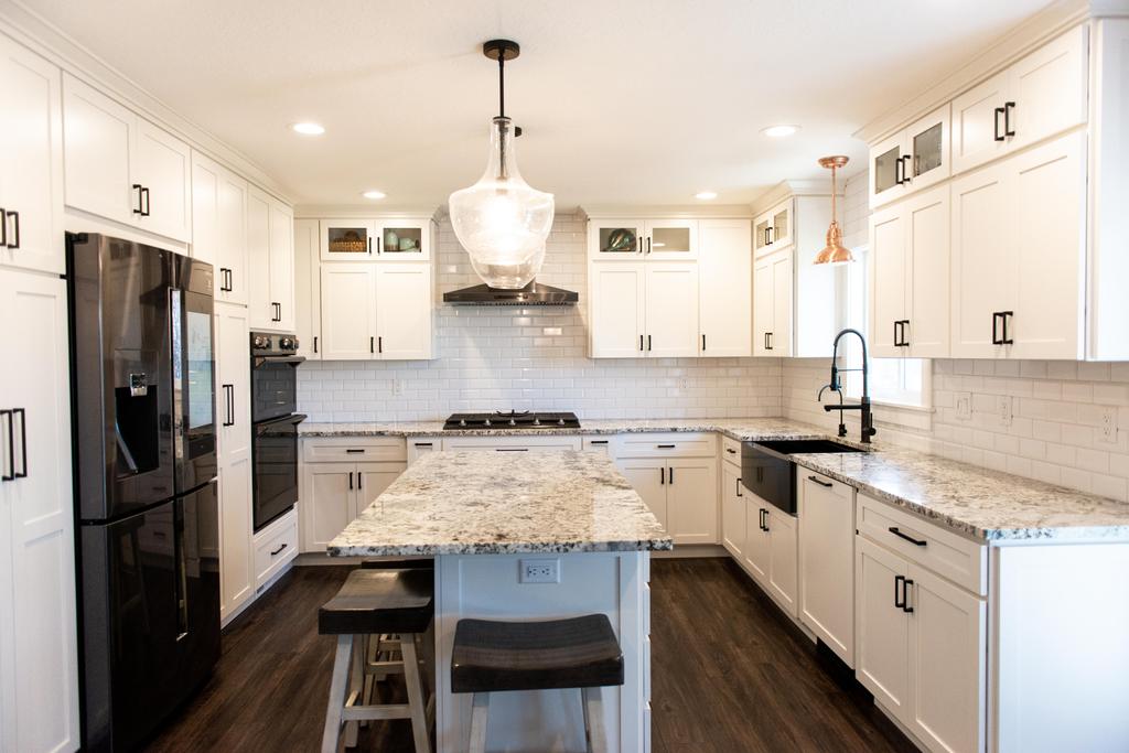 Whisper white granite countertop, Jeffery Alexander "Boswell" in Matte Black cabinet decorative pulls, maple wood full overlay pioneer door crown cabinets by DreamMaker Bath & Kitchen