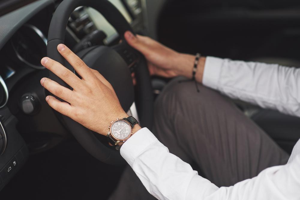 businessman-rides-his-car-moves-wheel-hand-with-watch by mloun