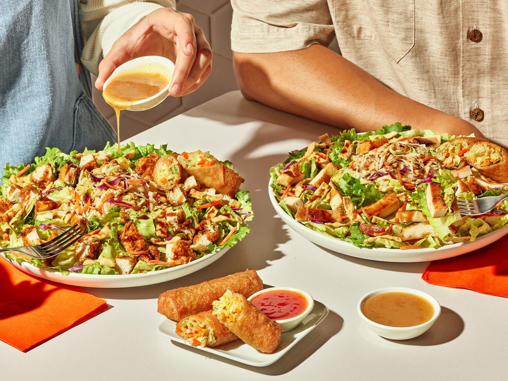 Two Zaxby's Asian Zensation Zalads topped with hand-breaded chicken and crispy egg rolls, served with Asian slaw and drizzled dressing. by Zaxbys Chicken Fingers & Buffalo Wings