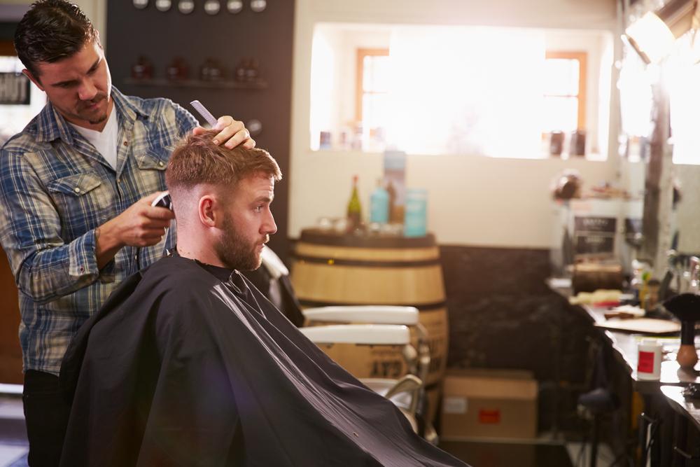 Male Barber Giving Client Haircut In Shop